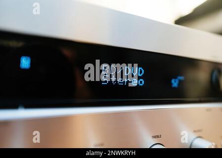 Makroaufnahme mit neigbarem Objektiv über BD DVD Blu-ray Disc Stereo Text auf dem LCD-Display Aluminiumfassade Stereo-Audio-HiFi-Receiver mit mehreren Knöpfen Stockfoto