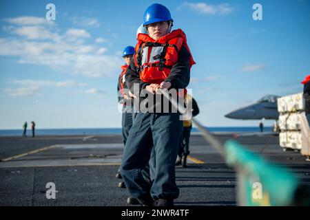 230207-N-FE499-1018 ATLANTISCHER OZEAN (8. Februar 2023) Seemann Samantha Gonzalez aus Loredo, Texas, spannt die Telefon- und Entfernungsleitung an Bord des Flugzeugträgers der Nimitz-Klasse USS Dwight D. Eisenhower (CVN 69) während einer Munitionsladung mit dem Trockenfracht- und Munitionsschiff USNS Medgar Evers (T-AKE 13). IKE führt derzeit im Rahmen seiner maßgeschneiderten Grundphase vor dem Einsatz Munition Onload, Cockpit-Zertifizierung und Luftflügelqualifizierung durch. Stockfoto