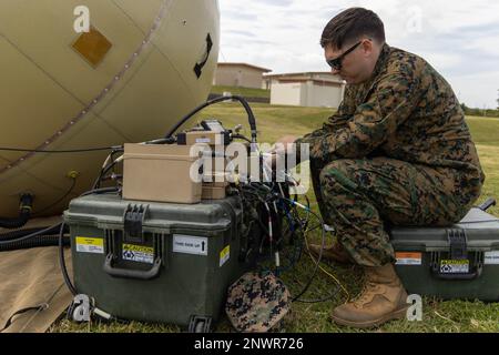 USA Sean Chapman, Stabschef des Marine Corps, ein Systemingenieur für Aufklärungs-, Überwachungs- und Aufklärungssysteme, mit 3. Nachrichtenbataillon, III Marine Expeditionary Force Information Group, installiert Kabel zu einem Satelliten mit hoher Bandbreite, der mit Spezialspionage palletiert wurde, um die Übung Azure Dragon in Camp Courtney, Okinawa, Japan, vorzubereiten, 9. Januar 2023. Azure Dragon ist eine von III MEF durchgeführte Übung, um Kriegsspielszenarien zu besprechen und zu planen. III MIG fungiert als Vorhut des III MEF und ist in der Informationsumgebung der Region Indo-Pazifik tätig und unterstützt Marine A Stockfoto