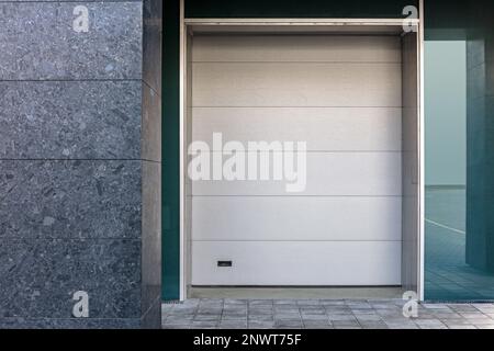 Geschlossene Rollladentür an der Gebäudefassade. Urbaner Hintergrund. Architektur. Stockfoto