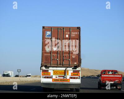 Gizeh, Ägypten, Januar 26 2023: Großer Tieflader-Lkw mit einem Stahlcontainer auf einer Autobahn in Ägypten, Versand- und Lieferservice-con Stockfoto