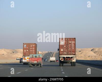 Gizeh, Ägypten, Januar 26 2023: Großer Tieflader-Lkw mit einem Stahlcontainer auf einer Autobahn in Ägypten, Versand- und Lieferservice-con Stockfoto