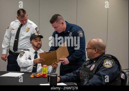 WASHINGTON ( Jan. 26,2023) Naval District Washington Police Officers überprüfen einen Lebenslauf auf der Strafverfolgungs- und Public Safety Jobmesse, die im Harborside Hotel in Oxon Hill, MD, stattfindet. Im Naval District Washington fand die Jobmesse statt, um kritische Positionen in mehreren Installationen in der Region zu besetzen. Stockfoto