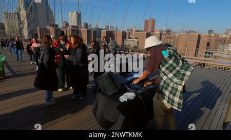 Leute, die Spaß auf der Brooklyn Bridge haben - NEW YORK, USA - 14. FEBRUAR 2023 Stockfoto