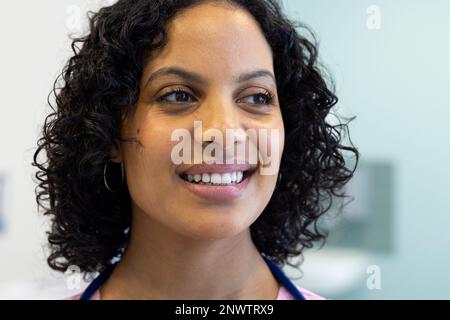 Glückliche birassische Ärztin mit lächelndem Stethoskop im Krankenhaus. Gesundheits-, Krankenhaus- und Pflegekonzept. Stockfoto