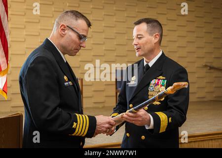 Fond ADM. Dennis Collins, Right, Commander, Navy Expeditionary Logistics Support Group, überreicht ein Geschenk an Captain Andrew Duessel, Commodore, Fourth Navy Expeditionary Logistics Regiment (NELR), während der Stilllegungszeremonie 4. NELR am Naval Station Mayport, Florida, 20. Januar 2023. Die vierte NELR verfügte über zahlreiche Kapazitäten, darunter die Durchführung von Vorbereitungstruppen für den Seeverkehr und gemeinsame Logistikoperationen über die Küste hinweg sowie die Unterstützung von Logistikoperationen für humanitäre Hilfe und zivile Unterstützung aus dem Ausland in der ganzen Welt. Stockfoto