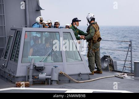 230205-N-HG846-1040 SÜDCHINESISCHE SEE (5. Februar 2023) – Naval Air Crewman (Helikopter) Rich Carlson aus Angle Inlet, Minnesota, tauscht Kommandoeinsätze mit Besatzungsmitgliedern an Bord der japanischen Seeschifffahrtsmacht JMSDF Takanami-Klasse Zerstörer JS Makinami (DD 112) während eines kombinierten Einsatzes mit dem Küstenschiff LUSS 18 Charleston Charleston (LUSCS) Im Südchinesischen Meer, Februar 5. Charleston, Teil des Destroyer-Geschwaders 7, ist im Rotationseinsatz im US-Flottenbereich 7. tätig, um die Interoperabilität mit Alliierten und Partnern zu verbessern und als Bereitschaftsdienst zu fungieren Stockfoto