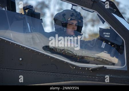 EIN US-AMERIKANISCHER Army AH-64 Apache Pilot wartet, bis ihr Flugzeug aufgetankt wird auf Marine Corps Air Station Beaufort, South Carolina, 5. Januar 2023. Der zum Auftanken verwendete Kraftstoff wurde bei einer Trainingsübung aus einer heißen Entleerung eines C-17 Globemaster III entnommen. Bei laufendem Triebwerk erfolgt eine Heißenttankung, wenn Kraftstoff aus einem Flugzeug entladen wird. Stockfoto