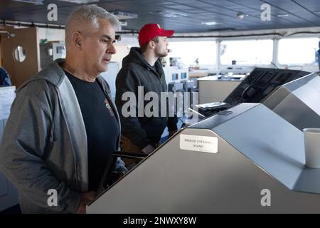 NORFOLK, Virginia (6. Februar 2023) Military Sealift Command Civil Service Mariner, Able Seaman Gerald Perry steuert das Trockenfrachtschiff der Lewis- und Clark-Klasse USNS Robert E. Peary (T-AKE 5), während das Schiff Seetests im Atlantik am 6. Februar 2023 durchführt. Während der Fahrt testete die Besatzung die Betriebsfähigkeit verschiedener Bordsysteme. Stockfoto