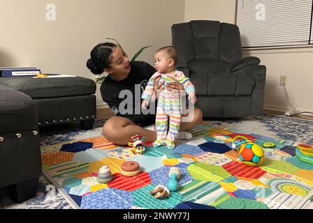SPC. Ayanna Rich spielt mit der 6 Monate alten Tochter Ariyah, nachdem sie sie von der Kindertagesstätte abgeholt hat. Sie kann mehr Zeit mit ihrer Tochter verbringen, da sie in der Nähe des Kinderentwicklungszentrums von Ariyah wohnt. Das ist nur einer der Vorteile, wenn man in einer Wohnung nach dem Wohnungsbau lebt. Stockfoto