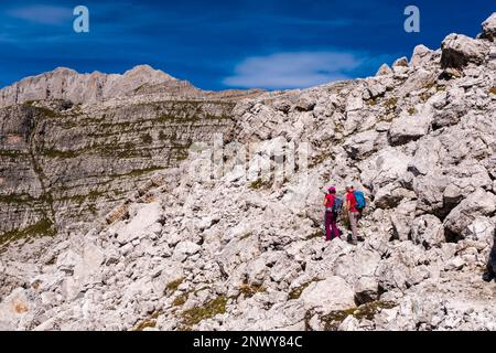 Zwei Wanderer auf dem Pfad zwischen der Berghütte Rifugio Francis Fox Tuckett und Passo del Groste an der Hauptstrecke der Dolomiten von Brenta. Stockfoto