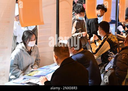 HANDAN, CHINA - 1. MÄRZ 2023 - Hochschulabsolventen kommunizieren mit Mitarbeitern von Unternehmen in Handan, Provinz Hebei, China, 1. März 2023. Stockfoto