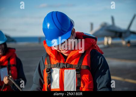 230207-N-FE499-1051 ATLANTISCHER OZEAN (8. Februar 2023) Seemann Gabriel Rivera vom Big Bear Lake, Kalifornien, spannt die Telefon- und Entfernungsleitung auf dem Cockpit an Bord des Flugzeugträgers der Nimitz-Klasse USS Dwight D. Eisenhower (CVN 69) während einer Munitionsladung mit dem Trockenfracht- und Munitionsschiff USNS Medgar Evers (T-AKE 13). IKE führt derzeit im Rahmen seiner maßgeschneiderten Grundphase vor dem Einsatz Munition Onload, Cockpit-Zertifizierung und Luftflügelqualifizierung durch. Stockfoto