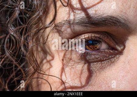 Gesicht einer jungen Frau mit lockigem schwarzem Haar und braunen Augen Stockfoto
