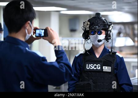 Während des mehrtägigen Hafens von Kimball in Kagoshima, Japan, am 13. Februar 2023 versuchen die Soldaten der japanischen Küstenwache bei einer Tour durch den Küstenwache Cutter Kimball (WMSL 756) die Ausrüstung der Strafverfolgungsbehörden anzuziehen. Kimballs Besatzung ist in Kagoshima, um gemeinsame Schulungen und einen professionellen Austausch mit Mitgliedern der japanischen Küstenwache durchzuführen und damit eine Kooperationsvereinbarung auszubauen, die 2022 zwischen den beiden Seeverkehrsdiensten unterzeichnet wurde und mit der die Operation SAPPHIRE, eine Daueroperation zur Stärkung der Beziehungen, zur Verstärkung bilateraler Engagements, eingeführt wurde; Und konzentrieren Sie sich auf die Aufrechterhaltung eines freien und offenen Indo-Pacific. USA Küsten-Gua Stockfoto