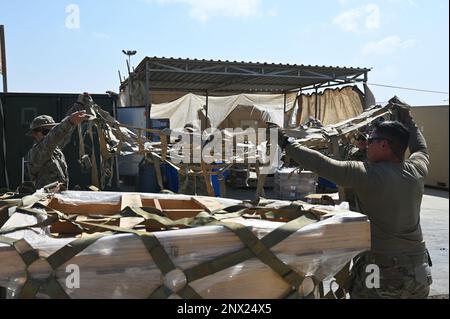 USA Spezialisten für die Materialverwaltung der Luftwaffe für die 726. Expeditionstruppe der Luftwaffe (EABS) wickeln eine Palette mit Fracht im Camp Lemonnier, Dschibuti, am 7. Februar 2023 um. Die Versorgungsspezialisten des EABS 726. sind nicht nur für Camp Lemonnier verantwortlich, sondern auch für andere Standorte in Ostafrika. Stockfoto