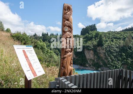 Eine hölzerne Puff-Schnitzerei eines Taniwha aus der Maori-Mythologie neben dem Rakaia River und der Schlucht in Aotearoa Neuseeland. Stockfoto