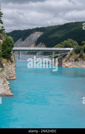 Die Rakaia River Gorge und die umliegende Landschaft, eine historische Brücke führt über das blaue Wasser, bestehend aus Gletscherschmelzwasser in Neuseeland. Stockfoto