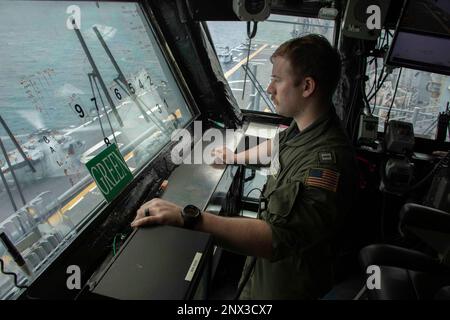 ATLANTIK (1. Februar 2023) Amphibienschiff der Wasp-Klasse USS Bataan (LHD 5) Offizier der Hangar Bay Division LT. Kyle Hatcher beobachtet den Cockpit-Betrieb in der primären Cockpit-Kontrolle des Schiffes (1. Februar 2023). Die USS Bataan, das Amphibiengeschwader 8 (PHIBRON) und die 26. Marineexpeditionseinheit (MEU), die alle Teil der Bataan Amphibious Readiness Group (BATARG) sind, nehmen derzeit an einer PHIBRON-MEU-Übung zur integrierten Ausbildung (PMINT) Teil. Stockfoto