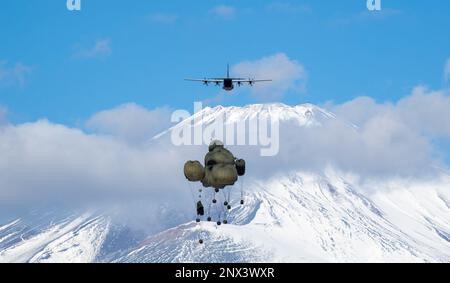 Die schweren Containersysteme (CDS) der japanischen Ground Self-Defense Force fallen aus den USA Air Force C-130J Super Hercules wurde der 36. Airlift-Geschwader im JGSDF East Fuji Manöver Area, Japan, am 31. Januar 2023 während der Airborne 23 zugeteilt. Neun C-130J-Flugzeuge, die der Yokota Air Base und der Little Rock Air Force Base, Arkansas, zugeteilt wurden, wurden verwendet, um während des Startsprungs-Teils der Übung etwa 300 JGSDF-Fallschirmjäger und CDS-Bündel in Abwurfzonen auf dem Higashi-Fuji-Trainingsfeld zu transportieren. Airborne 2023 ist ein groß angelegter Flugbetrieb, der Luft- und Bodenkräfte integriert Stockfoto