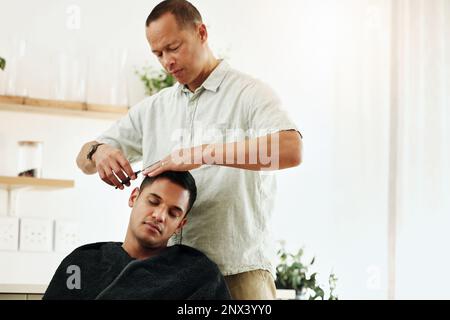 Friseur, Friseur und Stylist für Männer schneiden einen Kunden in einem Friseursalon, um ihn in einem Salon zu pflegen. Männlich, Friseur und Person bekommt Stockfoto