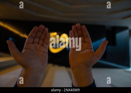Islamisches oder ramadan-Hintergrundbild. Muslimischer Mann betet in der Moschee und islamische Kalligraphie im Hintergrund. Selektiver Fokus. Istanbul Turkiye - 1 Stockfoto