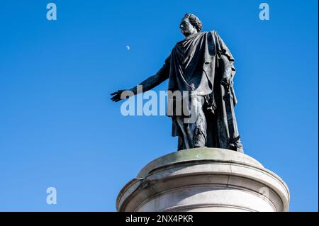 Die Statue von Ludwig XV, die vor blauem Himmel und Mond auf dem Place Royal in Reims, Frankreich, steht Stockfoto