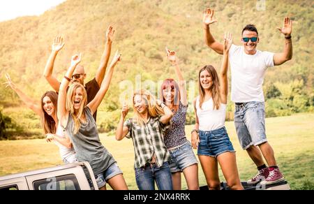 Eine Gruppe glücklicher Freunde, die Spaß auf einer Landparty im Pick-up-Truck haben - Freundschaftskonzept mit jungen Menschen, die Zeit zusammen auf dem Bauernhof verbringen Stockfoto