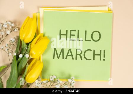Hallo märz – Frühlingspostkarte mit gelben Tulpen und Text Stockfoto