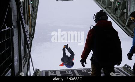 Pararescuemen von der 212. Rettungsschwadron Fallschirm aus einem 211. RQS HC-130J Kampfflugzeug King II über dem unteren Susitna Valley nahe Anchorage, Alaska, 7. Februar 2023. Die HC-130J und das Rettungspersonal sind zusammen mit dem 210. RQS HH-60G Pave Hawk Helikopter wachsam für die bundesstaatliche Such- und Rettungsmission in der riesigen arktischen Region Alaskas. Die Luftbetankungskapazität des HC-130F erweitert das Angebot des HH-60G Pave Hawk für Such- und Bergungsmissionen erheblich. Stockfoto