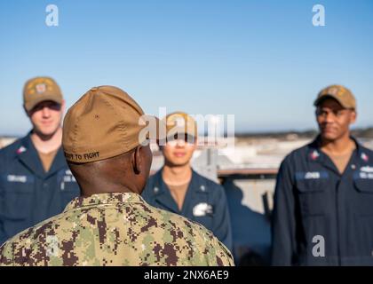 VIRGINIA BEACH, Virginia (10. Januar 2023) – Kommandomeister Huben Phillips, Kommandomeister der US-2.-Flotte, spricht mit Seeleuten an Bord des Landungsschiffs USS Carter Hall (LSD 50) der Harpers Ferry-Klasse für einen Schiffsbesuch, 10. Januar 2023. Während seines Besuchs überreichte Dwyer den schwer beladenen Matrosen Münzen und sprach mit der Crew über seine Erwartungen an die zukünftige Arbeit der Bataan Amphibious Ready Group (ARG). Stockfoto