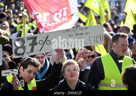 Gelsenkirchen, Deutschland. 01. März 2023. Auffallende junge Menschen stehen auf dem Heinrich-König-Platz mit einem Schild mit der Aufschrift "87% Inflation - wo ist die Entschädigung". Im Tarifstreit im öffentlichen Sektor fordert die Gewerkschaft Verdi einen landesweiten Warnstreik für Praktikanten und Doppelstudenten. Kredit: Federico Gambarini/dpa/Alamy Live News Stockfoto