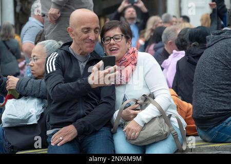 Ein Paar mittleren Alters schaut sich seine Selfie-Fotos auf der Piazza San Marco in Venedig an Stockfoto