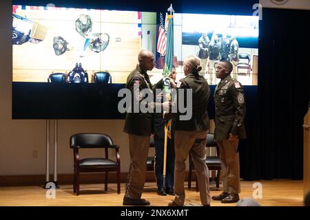 Das Kommando-Team der Soldatenunterstützungsgruppe gibt die Farben der Einheit weiter, um die Übertragung der Verantwortung von Kommandodienstleiter Major Anthony J. Wilson, links, auf Kommandodienstleiter Major Justin E. Turner, rechts, während einer Zeremonie am 3. Februar anzuzeigen. Stockfoto