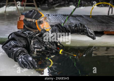 LITTLE FALLS, Minn. (6. Februar 2023) – USA Navy Chief Diver DJ Martinez, der Mobile Diving Salvage Unit 2 (MDSU 2) zugeteilt ist, bereitet sich auf den Sprung in Ferrell Lake in Little Falls, Minnesota, am 6. Februar 2023 während der Snow Crab Exercise 23-1 vor, einer Übung, die zum Testen und Bewerten der USA dient Fähigkeiten und Ausrüstung von Navy Explosive Ordnance Disposal (EOD) und Navy Diver in einer simulierten arktischen Umgebung und Verbesserung der Kampffähigkeit. Navy EOD und Navy Divers sind Teil der Naval Expeditionary Combat Force (NECF), die die USA unterstützt Marineflotte durch Räumung und Schutz des Kampfraums. Stockfoto