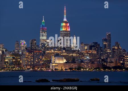 In New York City. Das Empire State Building und die Wolkenkratzer von Venderbilt werden für die LGBTQ+ Gay Pride Week in Regenbogenfarben beleuchtet. Midtown, Manhattan Stockfoto