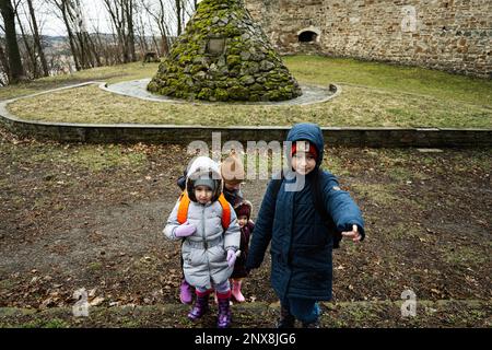 Mutter und Kinder gingen im Wald spazieren und bemerkten einen Tiergraben. Stockfoto