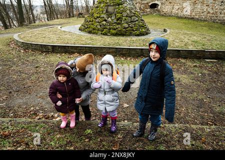 Mutter und Kinder laufen im Wald. Stockfoto