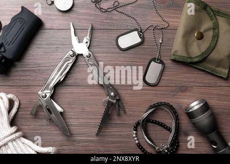 Flache Verlegung mit kompaktem tragbarem Multitool und Zubehör auf Holztisch Stockfoto