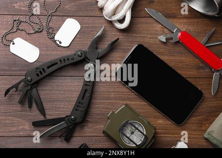 Flache Verlegung mit kompaktem tragbarem Multitool und Zubehör auf Holztisch Stockfoto