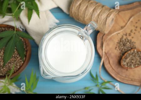 Krug mit Hanfmilch auf hellblauem Holzhintergrund, Draufsicht Stockfoto