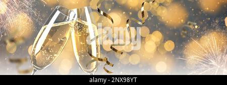 Gläser mit Sekt und glänzenden Schlangenschlangen gegen verschwommenes weihnachtliches Licht, Platz für Text. Bannerdesign Stockfoto