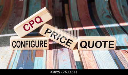 Hellen Sie Holzblöcke und -Würfel auf einem klassischen Hintergrund mit dem Text CPQ Configure Price Quote (CPQ Preisangebot konfigurieren) an Stockfoto
