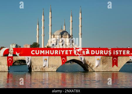 Die Steinbrücke und Sabanci Moschee, Adana, Türkei. Auf dem Banner auf der Brücke steht "die Republik verlangt eine klare Haltung" auf Türkisch. Stockfoto