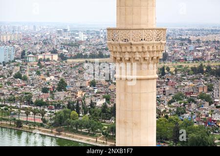 Luftaufnahme des Minaretts der Moschee Sabancı Merkez in Adana, Türkei, selektiv im Fokus. Der Blick auf die Stadt ist unscharf. Stockfoto