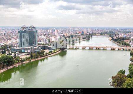 Aus der Vogelperspektive sehen Sie die türkische Stadt Adana, den Seyhan River, das Hilton SA Hotel und die historische Steinbrücke darüber. Stockfoto