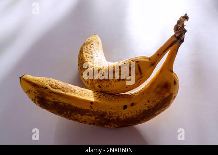Zwei reife Bananen auf weißem Tisch Nahaufnahme in interessanter Komposition 3 Stockfoto