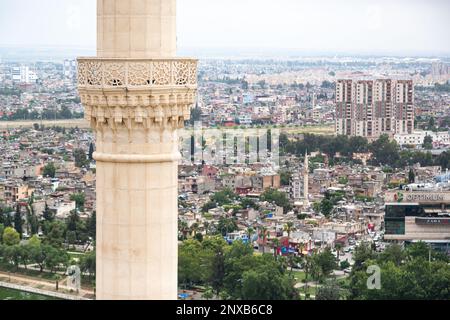 Luftaufnahme des Minaretts der Moschee Sabancı Merkez in Adana, Türkei, selektiv im Fokus. Der Blick auf die Stadt ist unscharf. Stockfoto