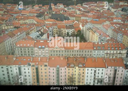 Blick auf die Häuser unten vom Fernsehturm Žižkov in Prag. Wohnblöcke, die einen Gemeinschaftsgarten umgeben. Stockfoto