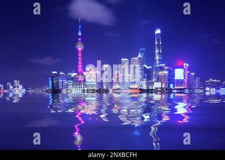 Verzerrte Wolkenkratzer-Reflexionen am Huangpu River bei Nacht, Shanghai, China Stockfoto